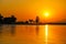 A gorgeous shot of a lake with rippling water at sunset with lush green trees and mountain ranges at Santa Fe Dam