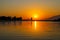 A gorgeous shot of a lake with rippling water at sunset with lush green trees and mountain ranges at Santa Fe Dam