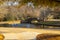 A gorgeous shot of a lake with a water fountain in the park near an arched cobble stone bridge