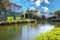 A gorgeous shot of the still lush green water of the canal with lush green trees and plants reflecting off the water