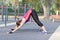 Gorgeous slim young woman practices yoga at outdoor sportsground. Down facing dog asana. Calmness and relax, stretching. Real woma