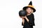Gorgeous smiling Halloween Witch holding large black pumpkin. Portrait of a beautiful young woman wearing witch hat. Halloween.