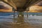 A gorgeous summer landscape at the beach under the Belmont Veterans Memorial Pier with blue ocean water and waves