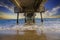 A gorgeous summer landscape at the beach under the Belmont Veterans Memorial Pier with blue ocean water and waves