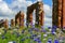 Gorgeous summer landscape with colorful cornflowers and the ruins of an old barn, made of boulders and red bricks