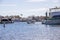 A gorgeous summer landscape with a man sailing a motor boat in the harbor with boats and yachts in the harbor