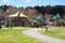A gorgeous summer landscape in the park with green park with a playground with jungle gyms and swings
