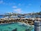 A gorgeous summer landscape at Redondo Beach Pier with a jetty made of large rocks and boats and ships sailing in the harbor