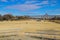 A gorgeous sunny day at Mud Island park with yellow winter grass, a colorful Memphis sign, bare winter trees, and buildings