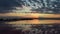 Gorgeous sunset sky reflecting in the water of a pink lake, people on the shore