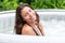 Gorgeous teenage girl with long, dark hair relaxes in the garden inflatable pool with jacuzzi