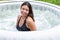 Gorgeous teenage girl with long, dark hair relaxes in the garden inflatable pool with jacuzzi