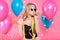 Gorgeous trendy young woman in party outfit celebrating birthday. Party mood, balloons, flying confetti, cocktail and dancing.