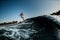 gorgeous view of adult man riding on the wave with hydrofoil foilboard on background of blue sky