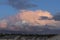 Gorgeous view of beautiful thunder clouds in blue sky above green tree tops.