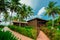 Gorgeous view of a bungalow house standing above the ground in front of the beach with ocean view on slightly cloudy da