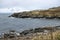 Gorgeous view of the grassy, rocky coastline on San Juan Island on a bright, sunny day with puffy white clouds