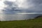 Gorgeous view of the grassy, rocky coastline on San Juan Island on a bright, sunny day with puffy white clouds