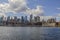 Gorgeous view of Hudson River, Manhattan skyscrapers and Brooklyn Bridge against blue sky with white clouds. New York.