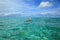 Gorgeous view of Indian Ocean, Maldives. Woman in hat swimming. Turquoise water surface and blue sky with white clouds. Beautiful