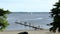 Gorgeous view of lake landscape. People on platform trying water. White sailboat on horizon. Sweden. Europe.