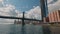 Gorgeous view of Manhattan skyscrapers and Brooklyn Bridge against blue sky with white clouds.