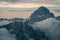 Gorgeous view of Mount Prisojnik in Slovenia with its peak beyond misty clouds at a pink sunset