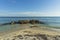 Gorgeous view of nature landscape. Seagulls on rocks on sandy coast of Atlantic ocean on blue sky background