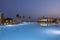 Gorgeous view of Portes Lithos Resort swimming pool with room blocks and sunset evening sky on background. Greece.