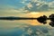 Gorgeous view of a reflective lake with a golden sun above it in Burla, Odisha India at sunset