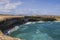 Gorgeous view of rocky coastline where big turquoise waves of Atlantic Ocean break on rocks.