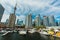 Gorgeous view of various yachts and boats parked on water, stylish inviting modern buildings, condos with people in background