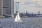 Gorgeous view of white sailboat with tourists on Manhattan buildings background.