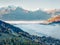 Gorgeous view of Zell lake in the morning mist with Grossglockner peak on background. Foggy autumn sunrise in Austria, Europe,