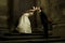 Gorgeous wedding couple bride and groom standing on staircase in front of historical church doorway and kissing