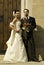 Gorgeous wedding couple bride and groom standing on staircase in front of historical church doorway and looking at camera