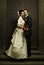 Gorgeous wedding couple bride and groom standing on staircase in front of historical church doorway and looking at camera