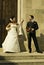 Gorgeous wedding couple bride and groom standing on staircase in front of historical church doorway and smiling