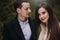 Gorgeous wedding couple gently hugging in winter snowy park. stylish bride in coat and  groom embracing under  trees in winter