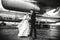 Gorgeous wedding couple poses under a huge wing of an airplane