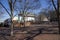 A gorgeous winter landscape at the Marietta Square with red brick footpath, bare trees, buildings and parked cars