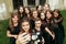 Gorgeous women group in black dresses taking selfie having fun and laughing in the city. stylish lady party with gothic theme.