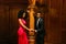 Gorgeous young african couple holding hands at the vintage column. Luxurious theatre interior background
