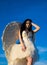 Gorgeous young brunette woman as angel in heaven with white wings.