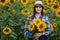 Gorgeous, young, energetic, female farmer holding many sunflowers in the middle of a green and golden sunflower field