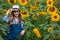Gorgeous, young, energetic, female farmer walking through a beautiful golden and green sunflower field