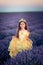 Gorgeous young girl with queen crown posing in the lavender field at sunset