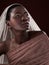 Gorgeously glowing. Studio shot of an attractive young woman posing in traditional African attire against a black