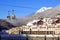 Gorky Gorod mountain ski resort townscape. Hotels on scenic snowy Caucasus mountain peaks background under blue sky at winter.