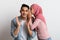 Gossips Concept. Muslim Woman In Hijab Whispering Secret To Her Surprised Boyfriend